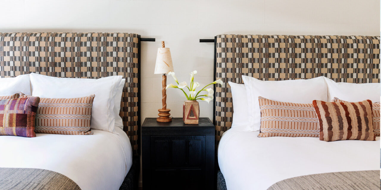 Double queen guest room with patterned headboards and warm modern décor