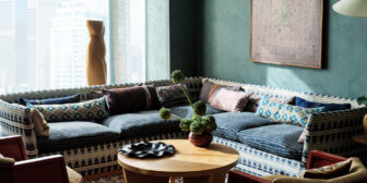 Spacious lounge area with patterned sectional seating, city views, and warm contemporary decor