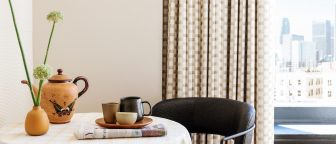 downtown la proper hotel suite seating area with newspaper and coffee