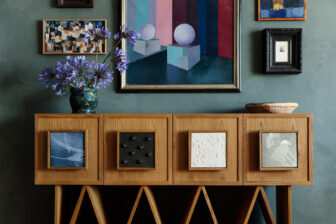 Artistic wood console with ceramic accents, floral arrangement, and contemporary wall art