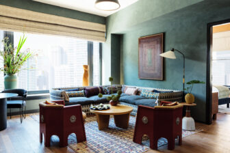 Modern suite lounge with patterned seating, curated decor, and skyline views through large windows