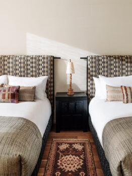 Double queen guest room with patterned headboards and warm modern décor