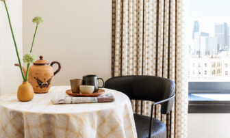 downtown la proper hotel suite seating area with newspaper and coffee