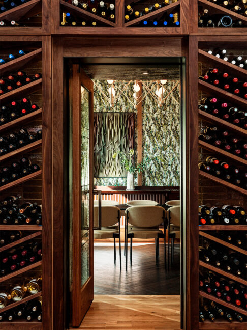 A cozy, design-forward nook framed by a curated wall of wine.