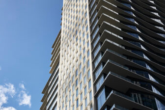 Modern high-rise exterior with clean lines, glass balconies, and contemporary architectural detail.