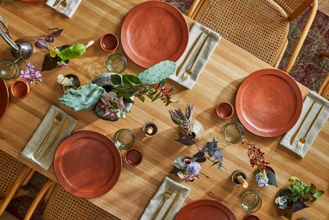 Overhead table setting with terracotta plates and floral decor
