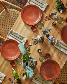 Overhead table setting with terracotta plates and floral decor