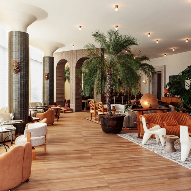 Bright, stylish lounge with modern seating, wood floors, and lush greenery in a spacious interior