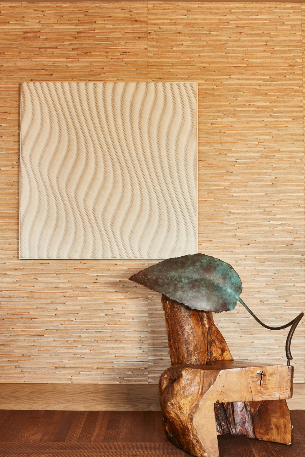 Sculptural wood chair with abstract wall art and textured wood paneling