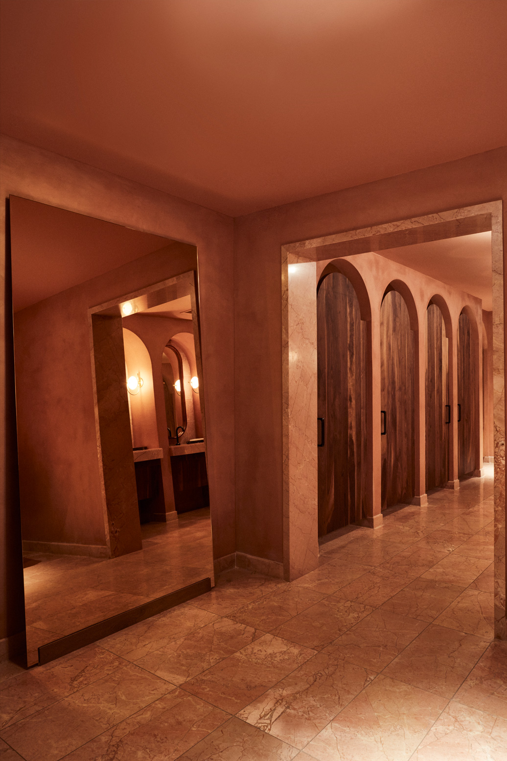 Warm toned hallway with arched doorways and marble accents