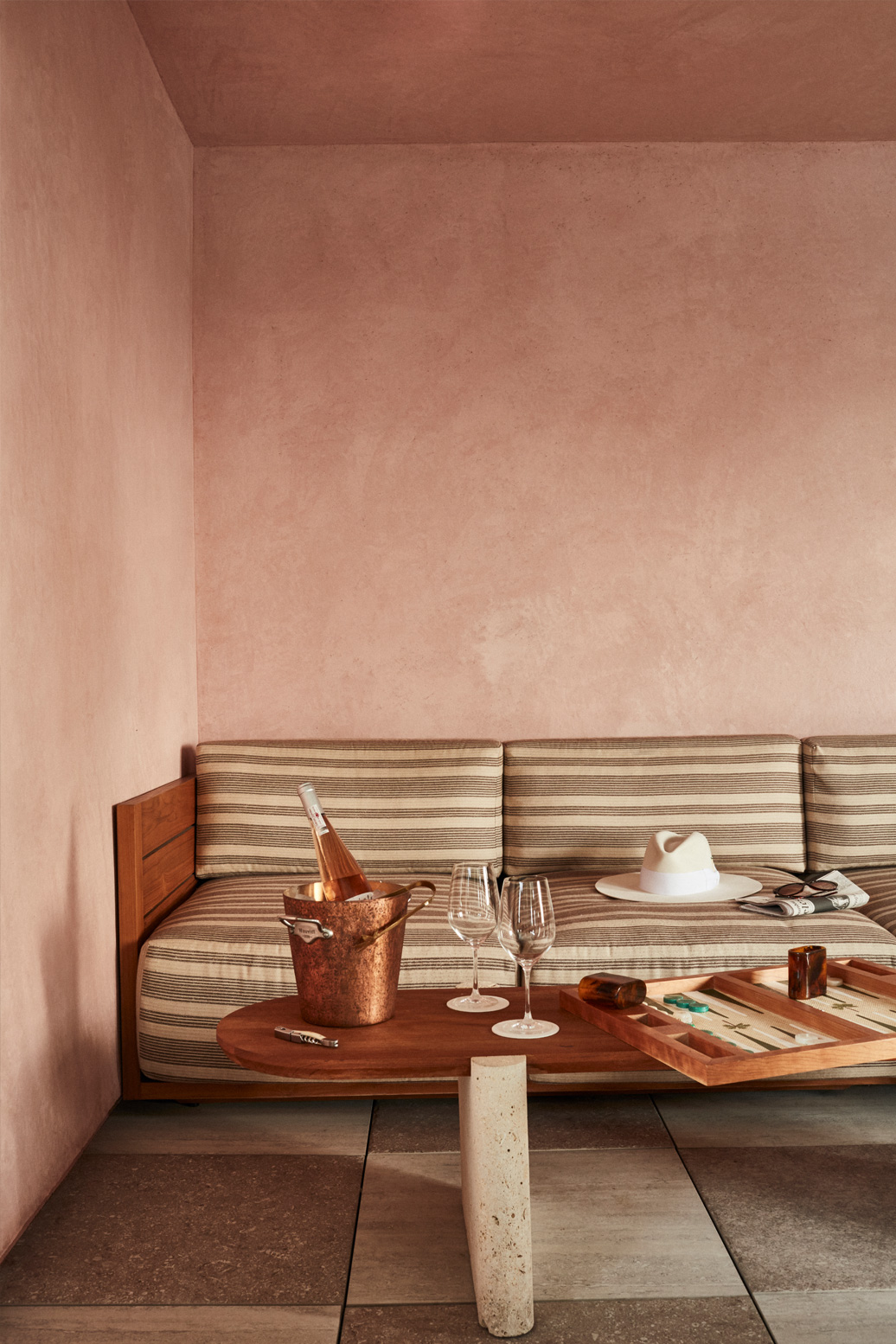 Poolside lounge seating with rosé, games, and warm neutral tones