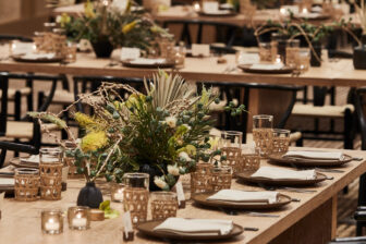 Elegant meeting setup with warm wood tables, soft lighting, and curated floral centerpieces.