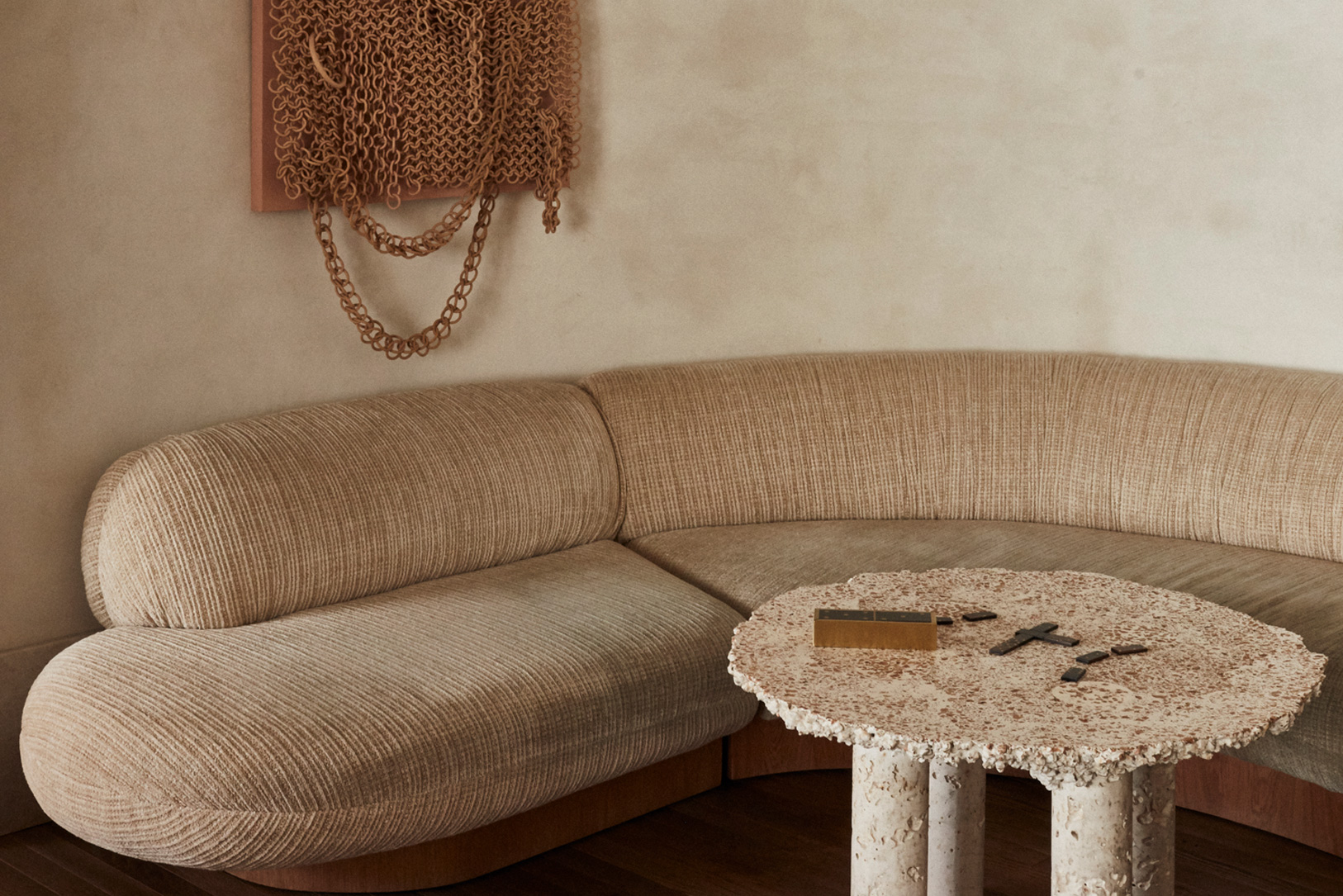 Soft, sculptural lounge with curved seating, neutral tones, and textured design details.