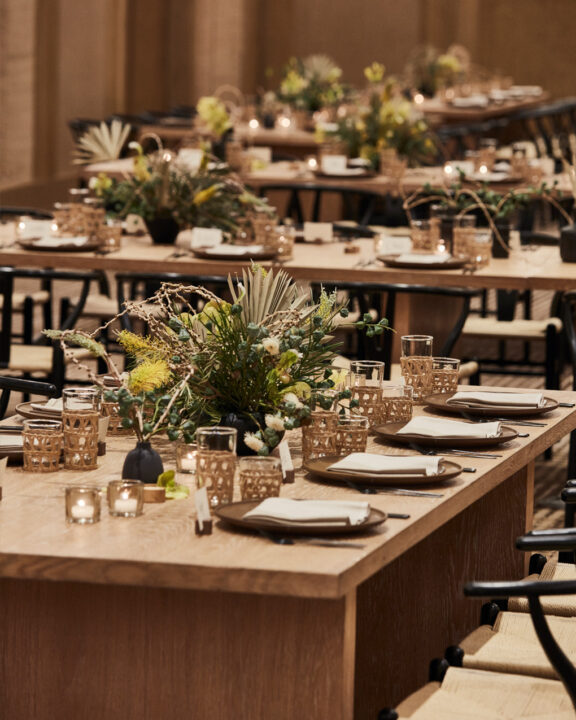 Elegant meeting setup with warm wood tables, soft lighting, and curated floral centerpieces.