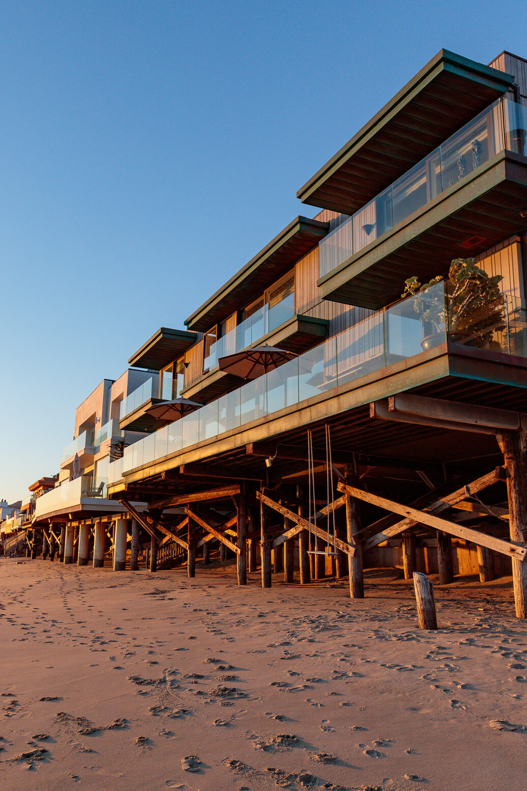 Exterior image of malibu beach house during sunset with view of huge outdoor terrace