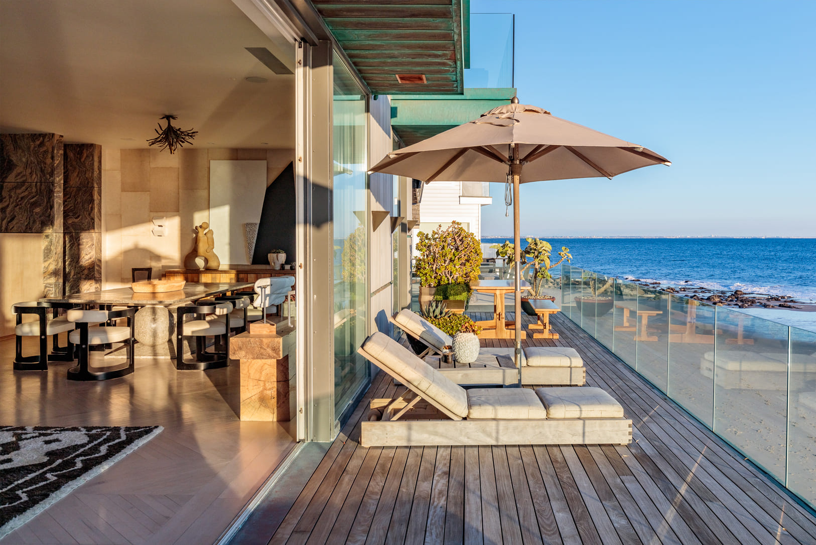 Malibu Beach House beach front terrace with lounge chairs and view of pacific ocean