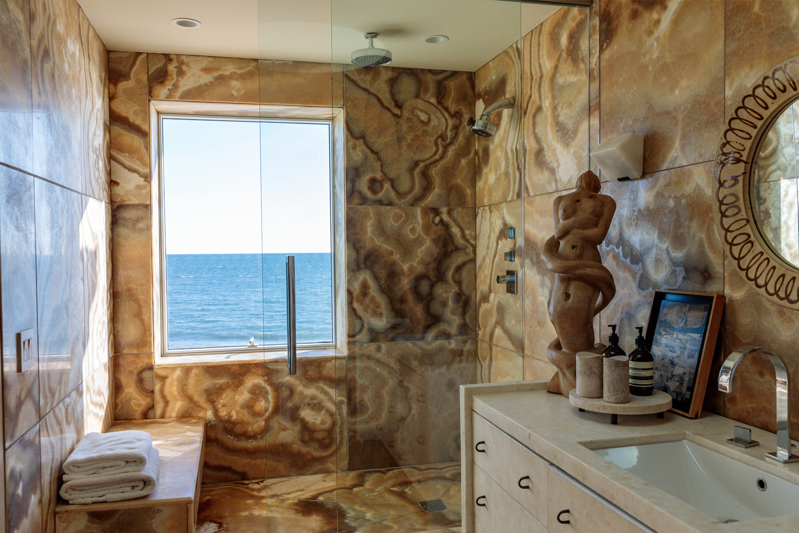 Ocean front bathroom with marble walls and walk-in shower