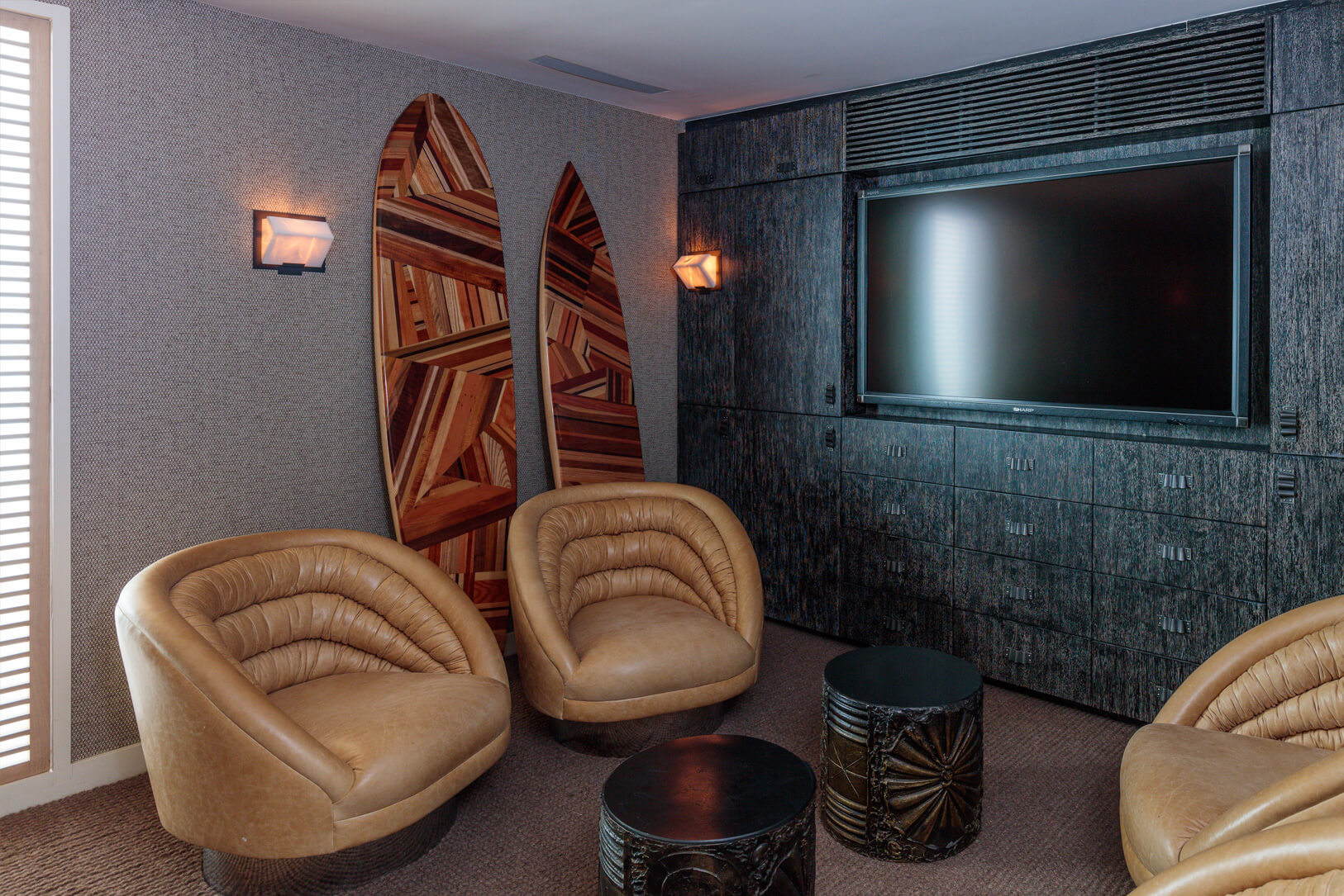 living room with huge tv, four chairs and two surfboards