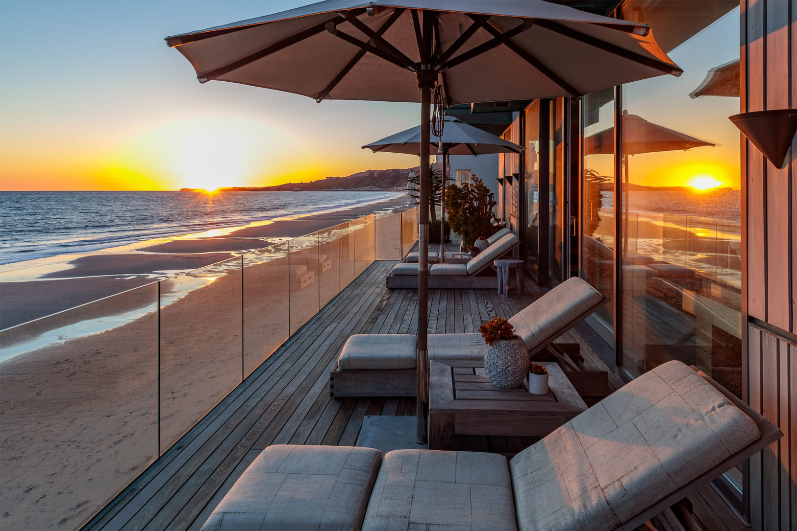Malibu Beach House beach front terrace with view of pacific ocean and sunset