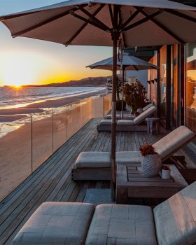 Malibu Beach House beach front terrace with view of pacific ocean and sunset
