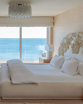 Ocean front bedroom with king bed, tv, and ocean front balcony