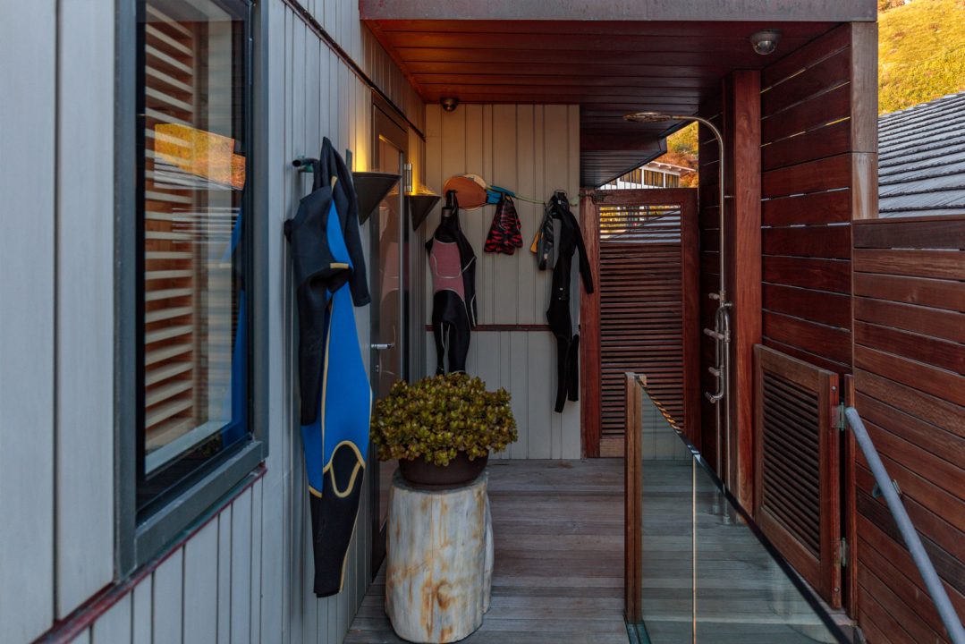 Outdoor shower with wet suits hanging