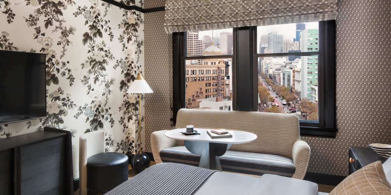 guest room with seating area and view of the city