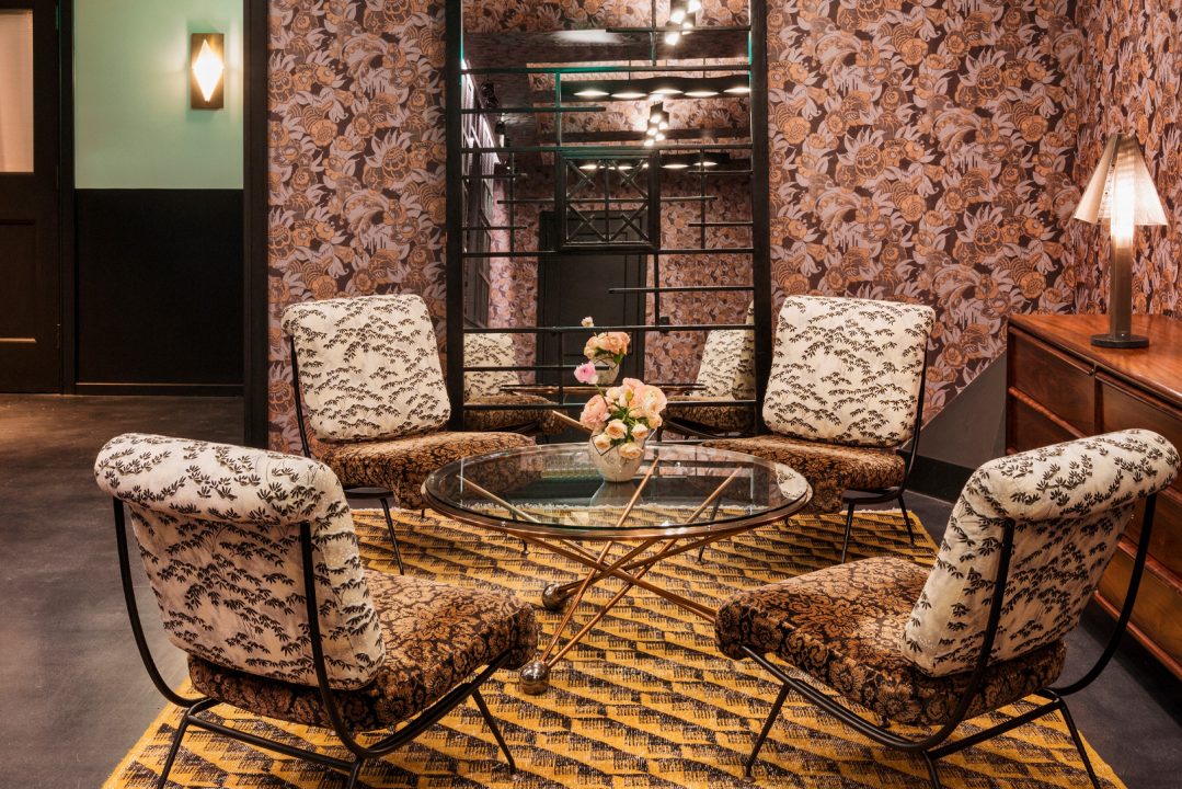Elegant hotel lounge seating area with patterned chairs and floral wallpaper