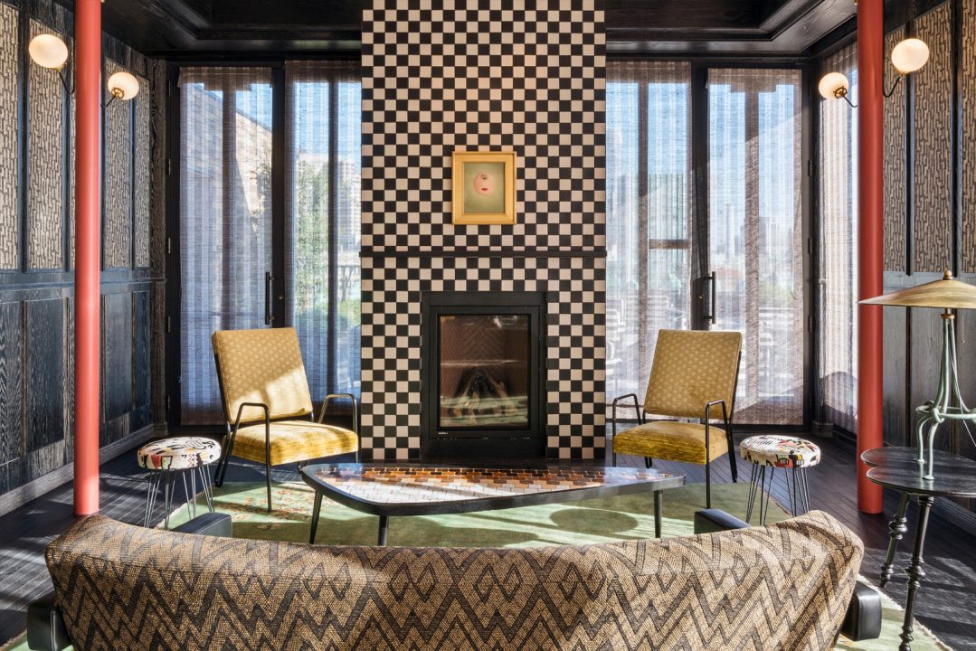 Stylish lounge seating area with fireplace and checkerboard accent wall