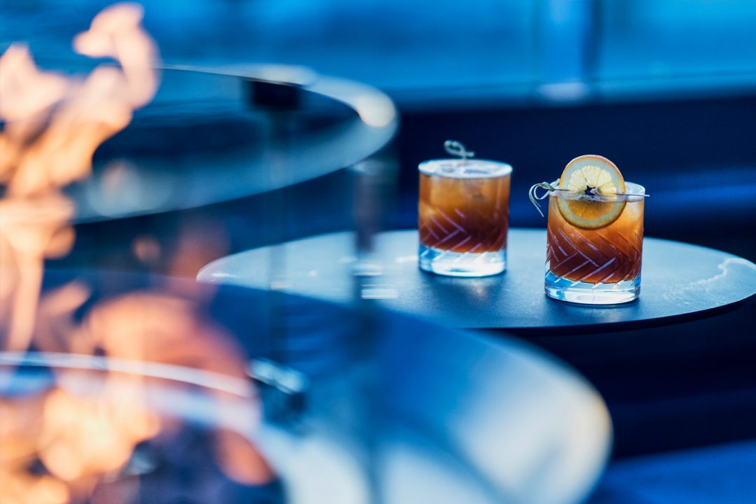 Craft cocktails served beside rooftop fire pit seating area