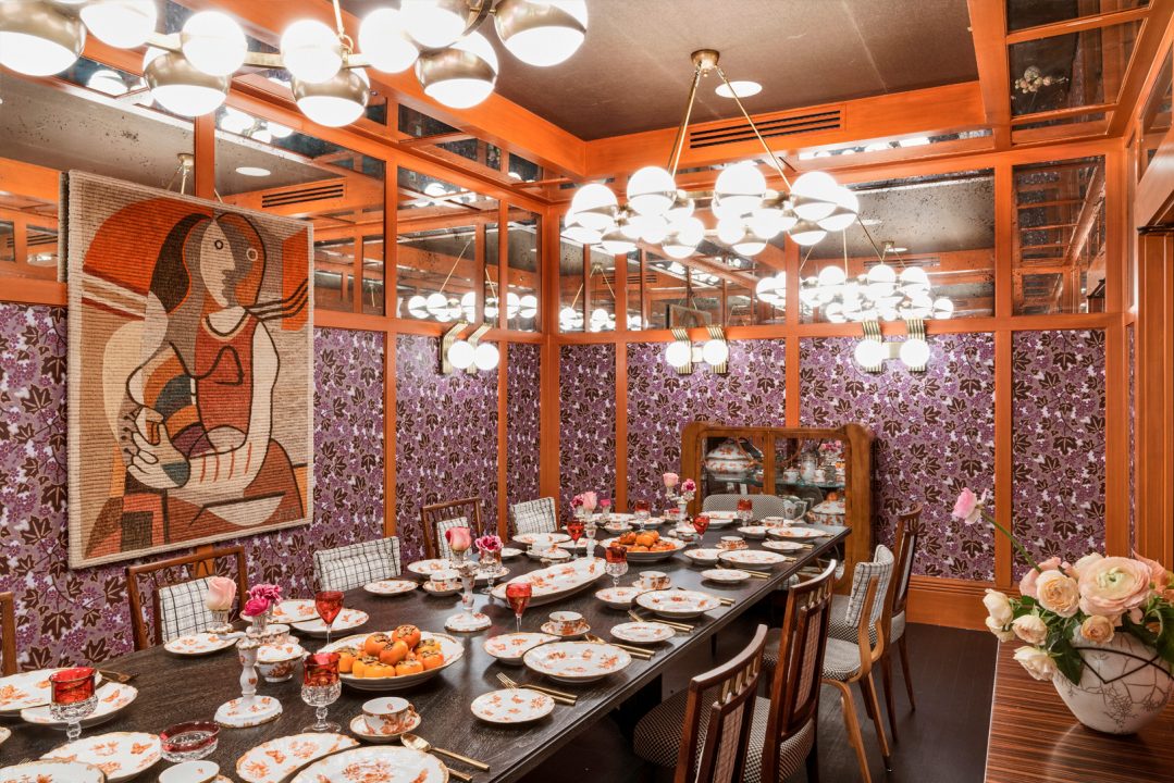 Elegant private dining room with floral decor, chandelier lighting, and long banquet table