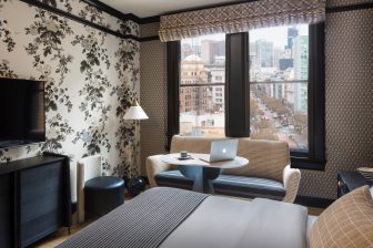 Hotel guest room with workspace seating and downtown city views