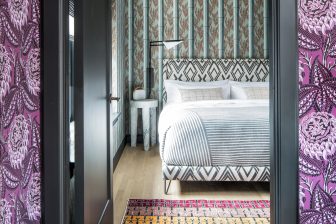 Boutique hotel guest room with patterned wallpaper and modern king bed