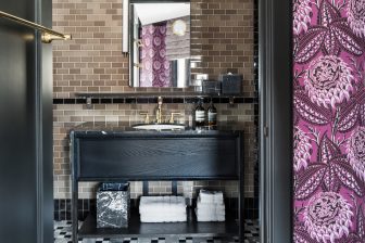 Modern hotel bathroom with tiled walls, marble accents, and luxury amenities