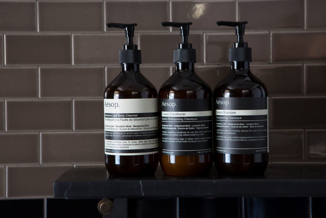 Luxury hotel bathroom amenities with shampoo, conditioner, and body cleanser bottles