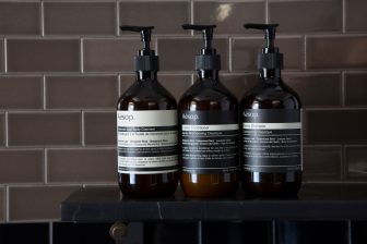 Luxury hotel bathroom amenities with shampoo, conditioner, and body cleanser bottles