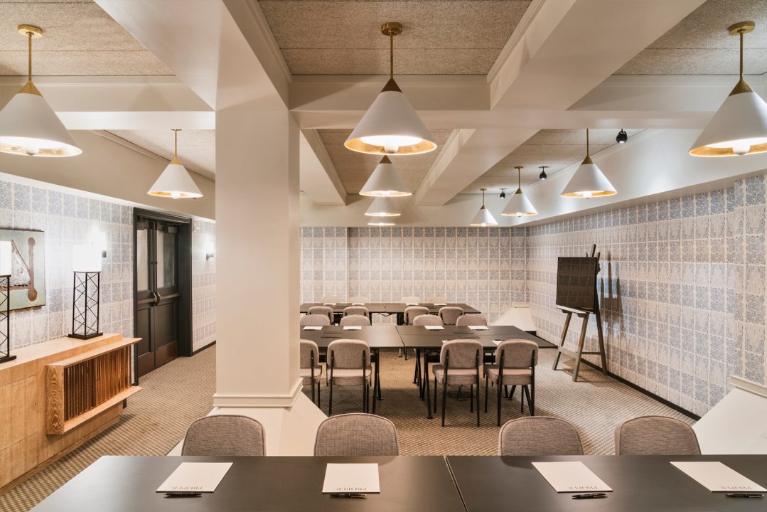 Modern hotel meeting room with conference seating and pendant lighting
