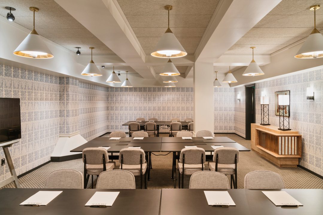 Modern hotel meeting room with conference seating and pendant lighting