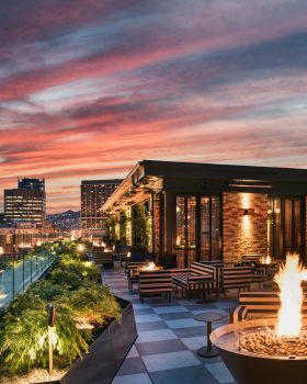 Rooftop lounge with fire pits, city views, and a cozy evening ambiance.