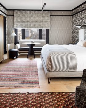 Modern luxury hotel room with plush bedding and panoramic downtown views