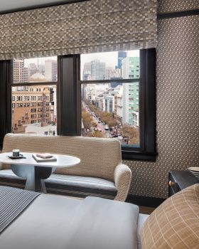 Hotel guest room with workspace seating and downtown city views