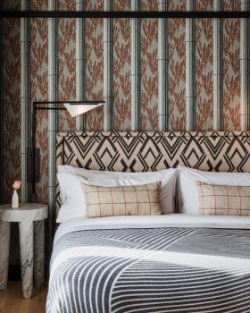 Stylish guest room detail with patterned headboard, layered textiles, and refined accents.