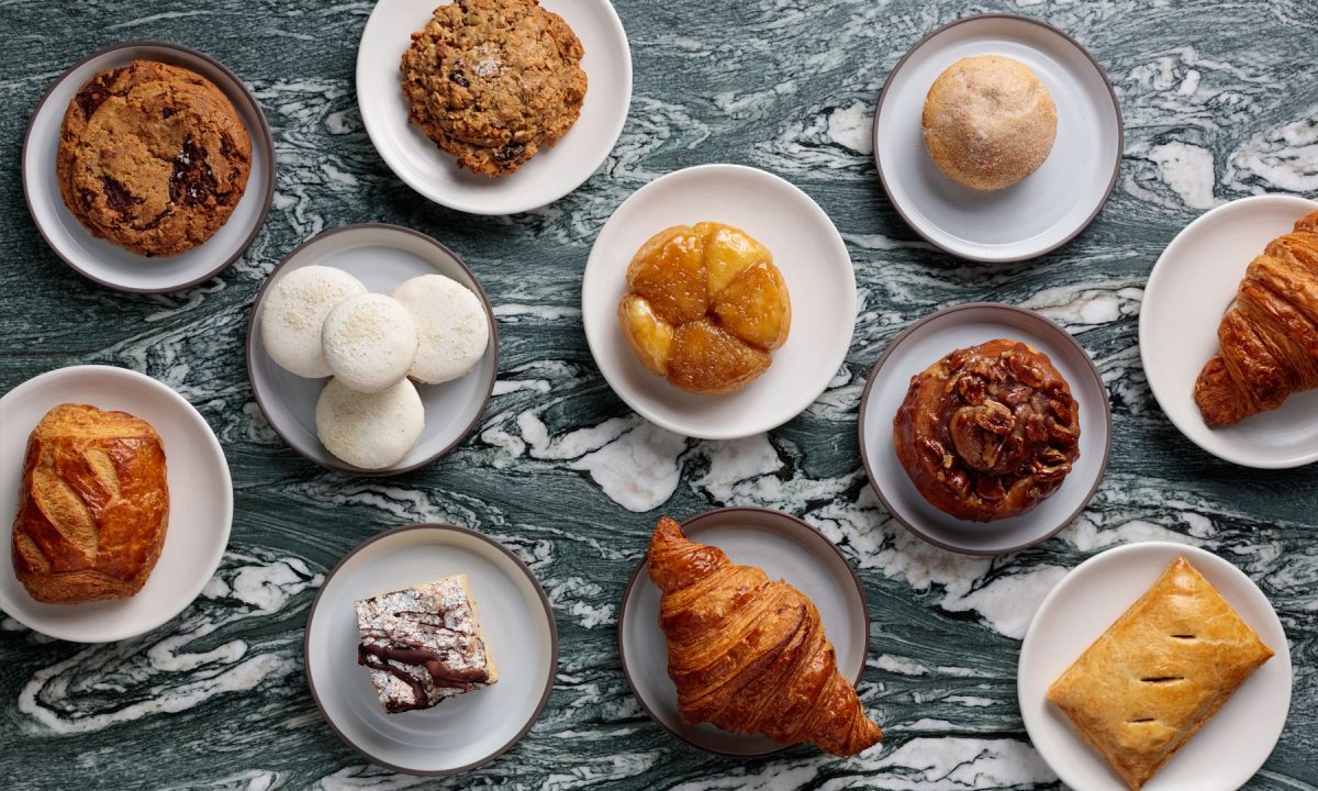 Assorted pastries and baked goods arranged on marble table at café bakery