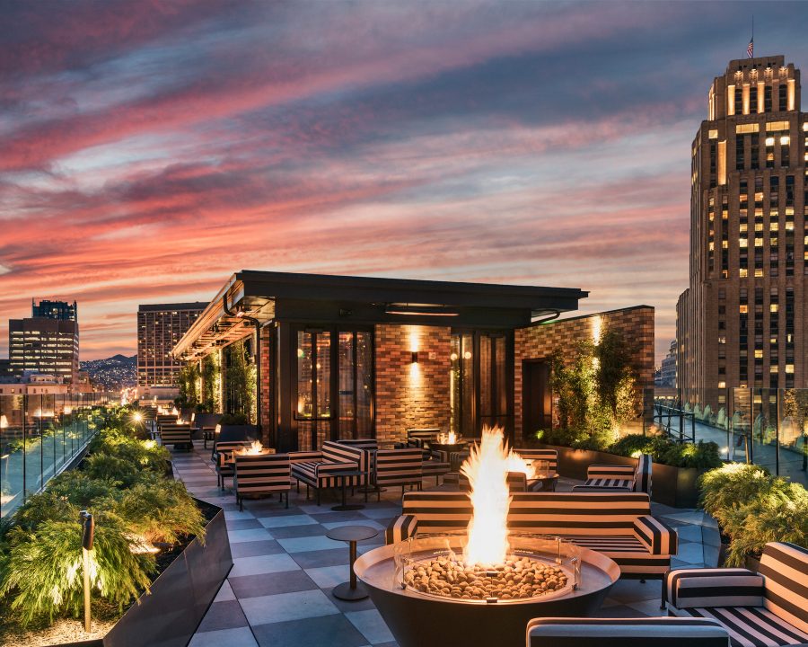 Rooftop lounge with fire pits, city views, and a cozy evening ambiance.