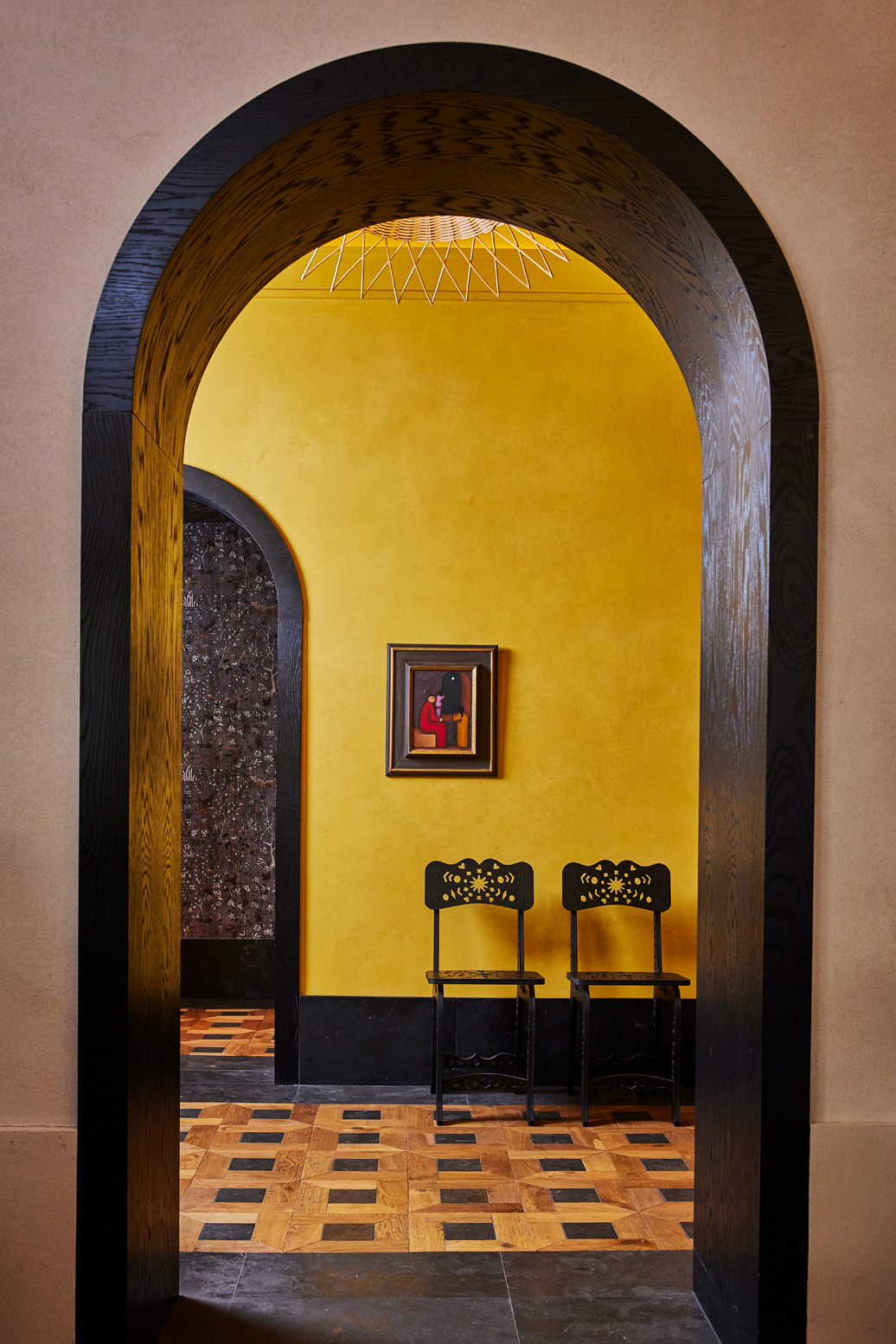 View of two chairs through walkway in lobby