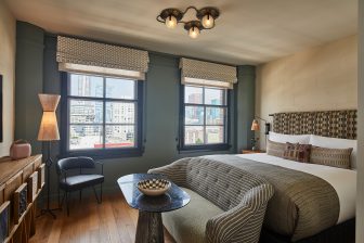 Sophisticated city view guestroom with layered textures and modern furnishings