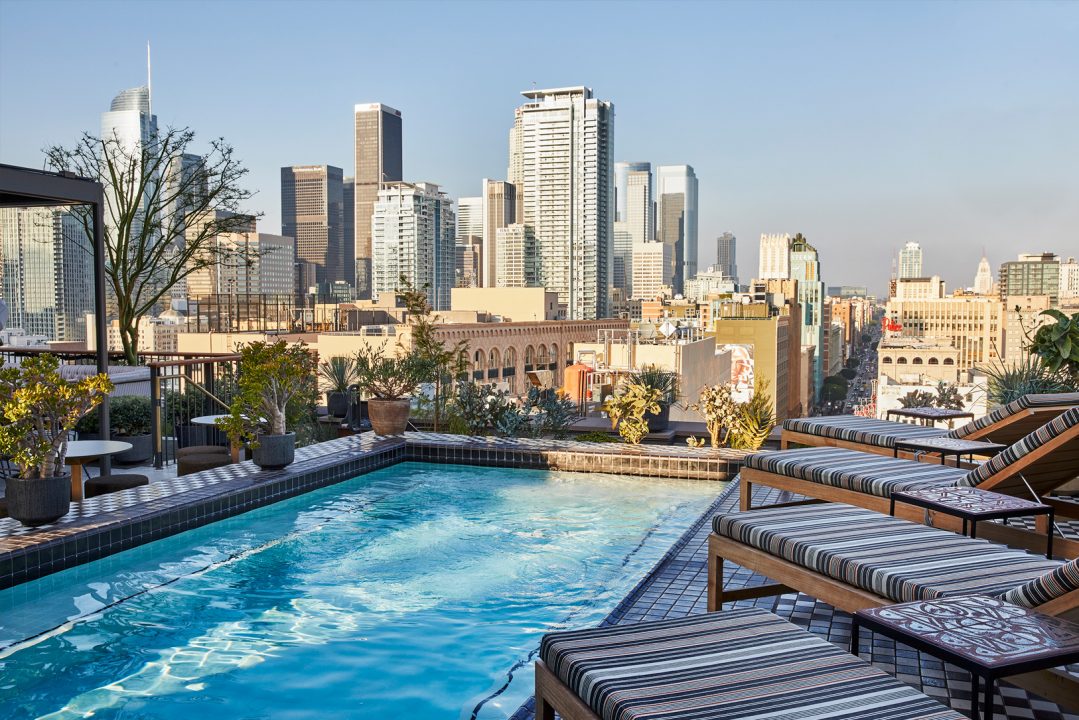 Rooftop Pool Deck with lounge chairs and view of downtown los angeles city skyline