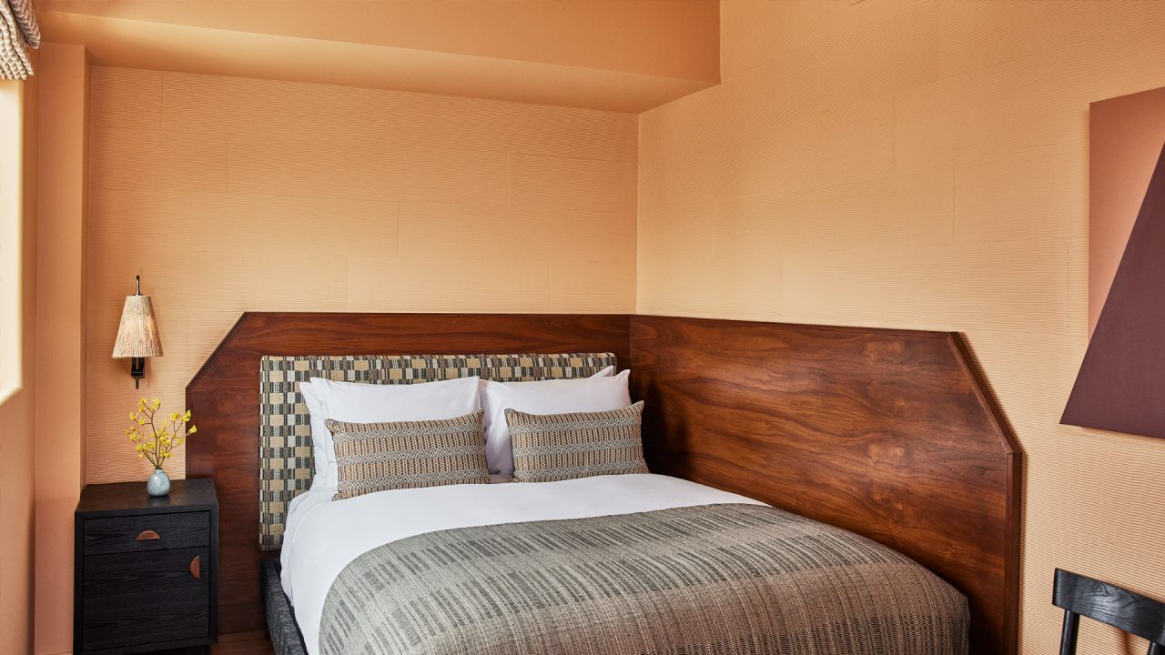Modern king guest room with custom wood headboard and warm neutral interiors