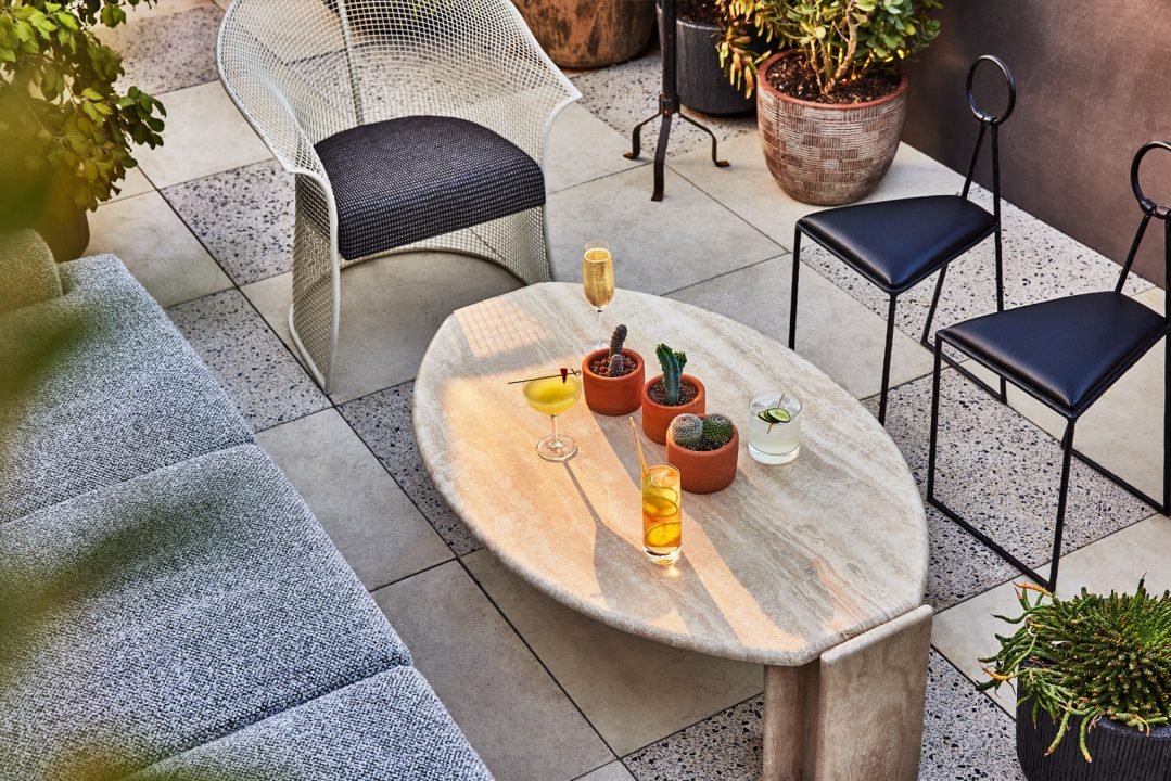 Rooftop lounge seating with handcrafted cocktails, marble table, and desert inspired decor
