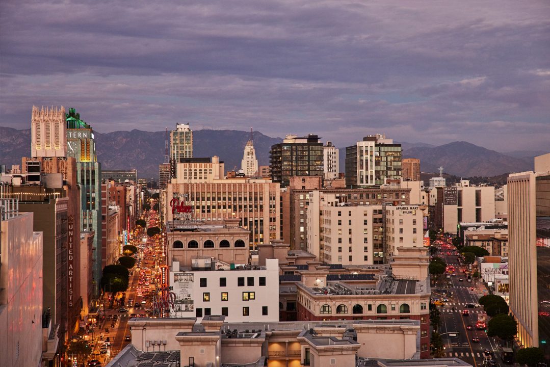 Panoramic Downtown Los Angeles skyline view with city lights and mountain backdrop at dusk